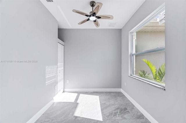 unfurnished room with ceiling fan and plenty of natural light