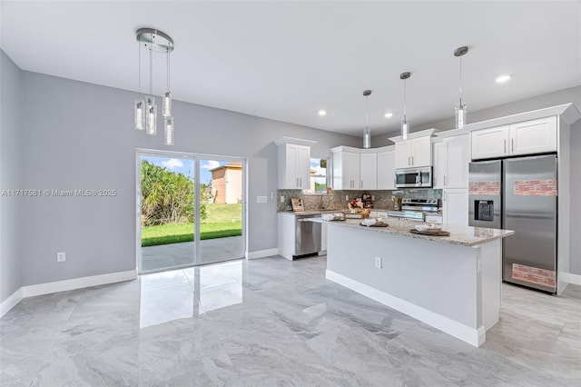 kitchen featuring white cabinetry, light stone countertops, decorative light fixtures, a kitchen island, and appliances with stainless steel finishes