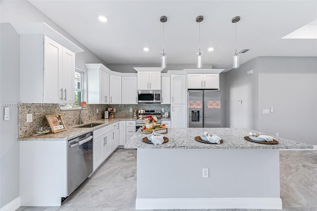 kitchen featuring a kitchen island, white cabinetry, sink, and appliances with stainless steel finishes