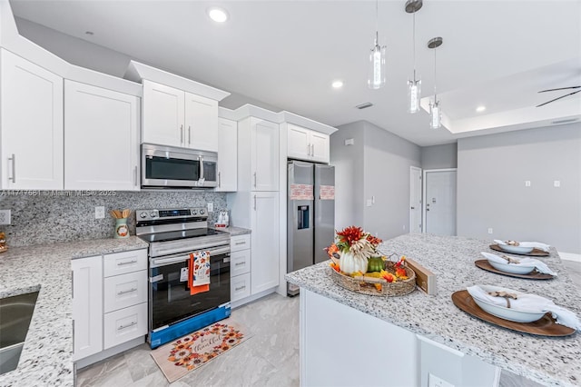 kitchen with backsplash, light stone counters, white cabinets, and appliances with stainless steel finishes