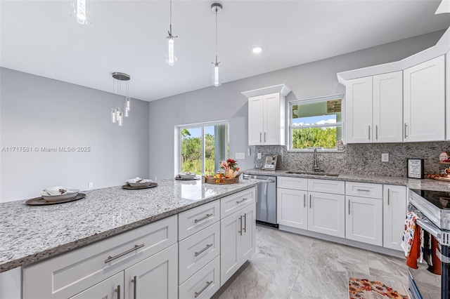 kitchen with backsplash, stainless steel appliances, sink, white cabinetry, and hanging light fixtures