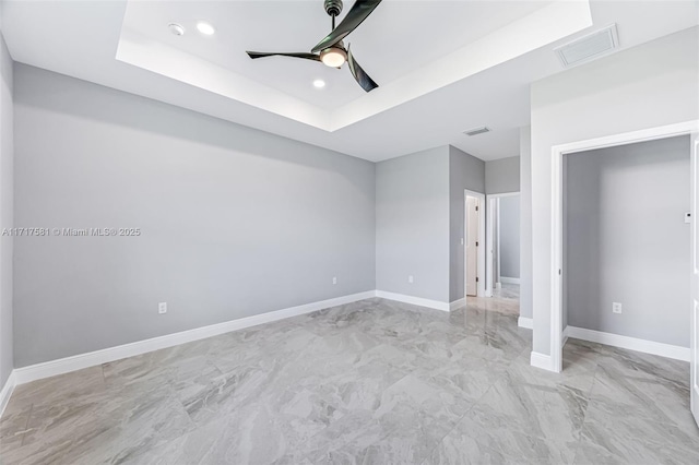 unfurnished bedroom featuring ceiling fan and a tray ceiling