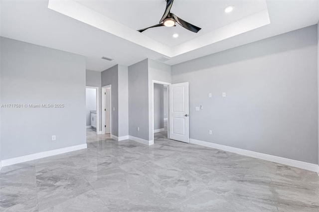 unfurnished bedroom featuring a tray ceiling and ceiling fan