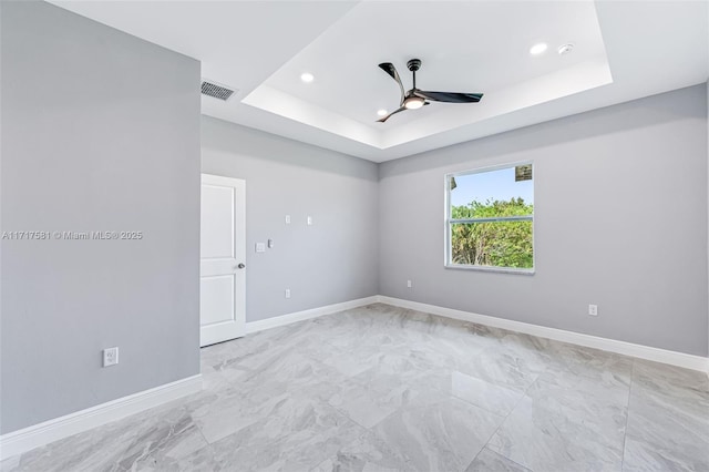 spare room featuring ceiling fan and a tray ceiling