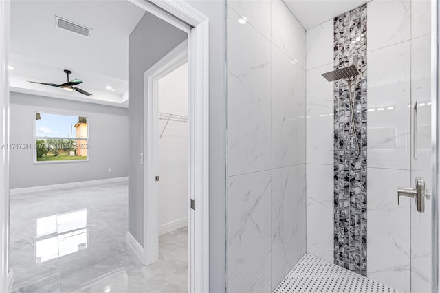 bathroom with tiled shower and ceiling fan