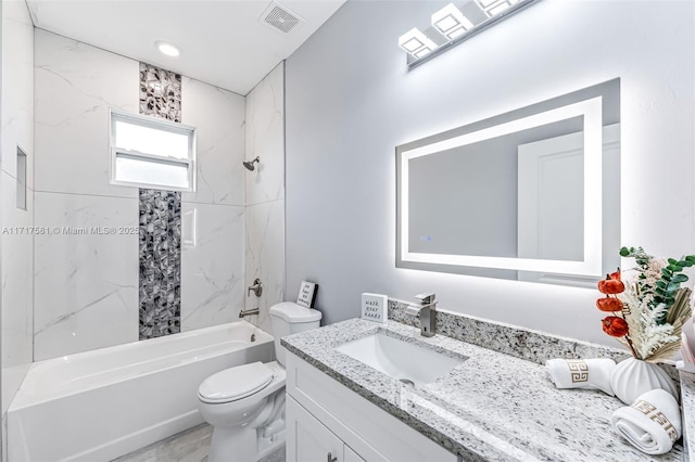 full bathroom with toilet, vanity, and tiled shower / bath