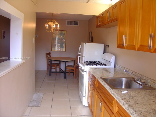 kitchen with white appliances, sink, pendant lighting, a chandelier, and light tile patterned flooring