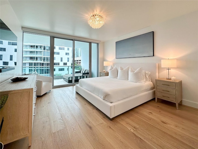 bedroom featuring a notable chandelier, floor to ceiling windows, light hardwood / wood-style flooring, and access to outside