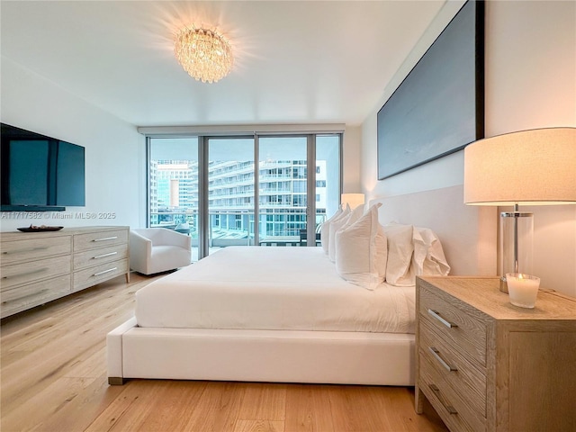 bedroom featuring expansive windows and light wood-type flooring