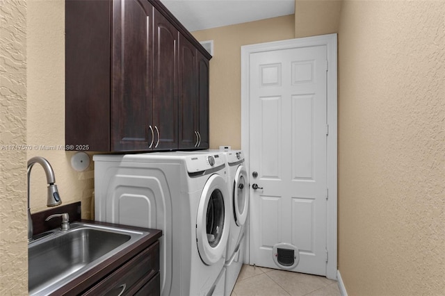 laundry room with cabinets, light tile patterned flooring, washer and clothes dryer, and sink