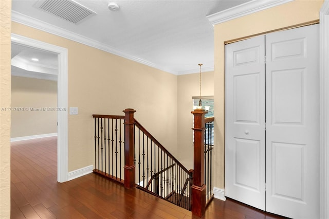 stairs with crown molding and wood-type flooring