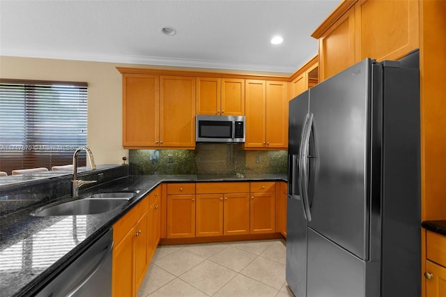 kitchen featuring sink, crown molding, dark stone counters, decorative backsplash, and appliances with stainless steel finishes