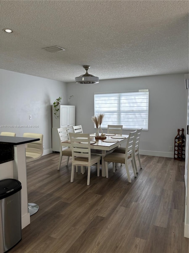 unfurnished dining area featuring a textured ceiling and dark hardwood / wood-style floors