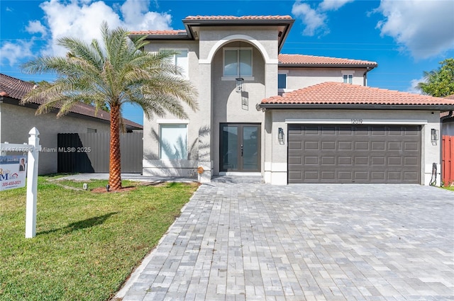 mediterranean / spanish home featuring a front yard and a garage