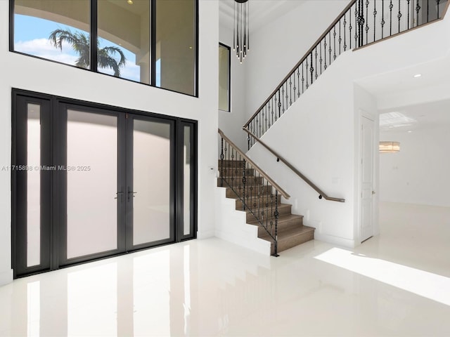 entrance foyer with a towering ceiling and french doors