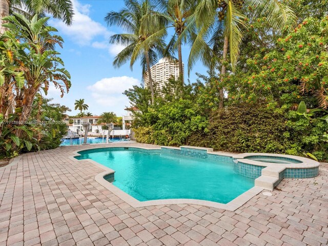 view of pool featuring an in ground hot tub