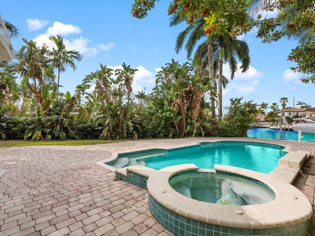 view of pool featuring an in ground hot tub and a patio