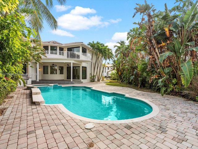 view of swimming pool with ceiling fan, an in ground hot tub, and a patio