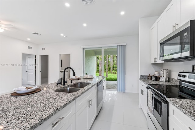 kitchen with light stone countertops, sink, white cabinetry, and stainless steel appliances