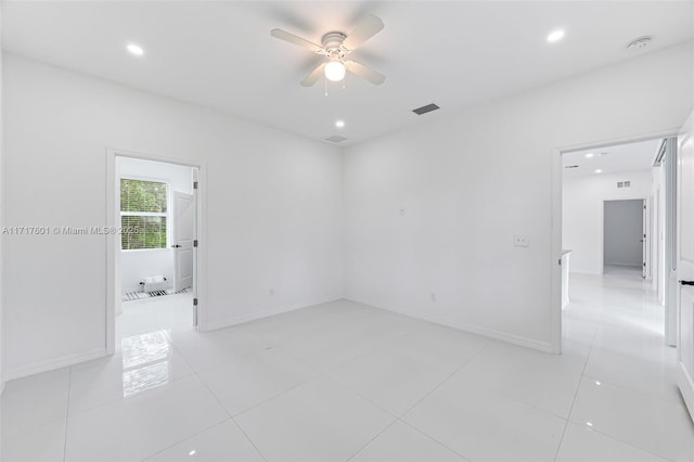 tiled empty room featuring ceiling fan