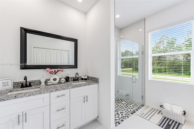 bathroom featuring tile patterned flooring, vanity, and a shower with door