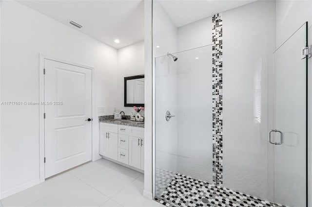 bathroom featuring tile patterned flooring, vanity, and walk in shower