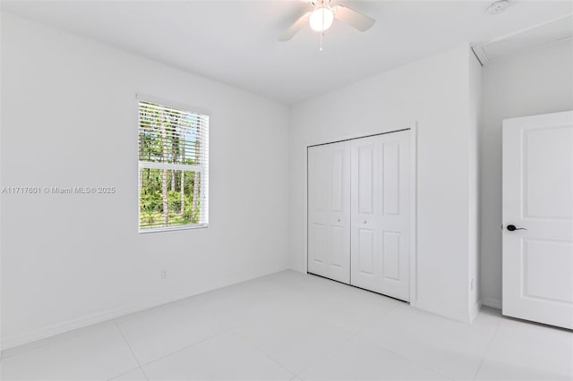 unfurnished bedroom with ceiling fan, light tile patterned flooring, and a closet