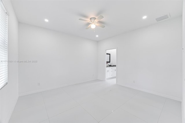 unfurnished room with ceiling fan, light tile patterned floors, and a wealth of natural light