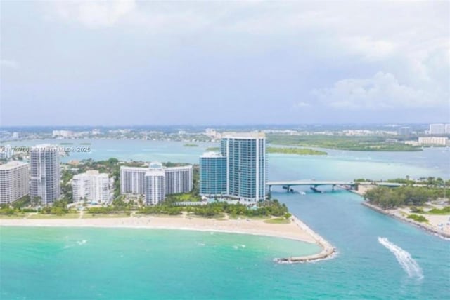 birds eye view of property featuring a water view and a beach view