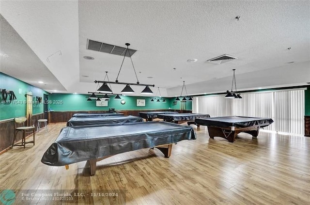 rec room featuring pool table, a textured ceiling, and light hardwood / wood-style flooring