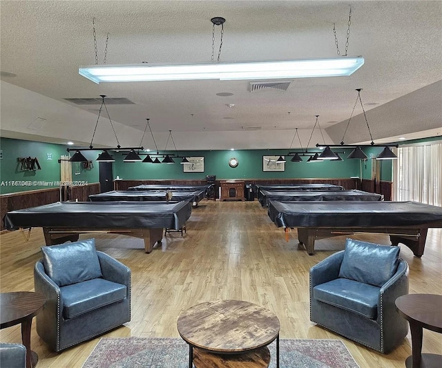 rec room featuring hardwood / wood-style flooring, lofted ceiling, a textured ceiling, and pool table