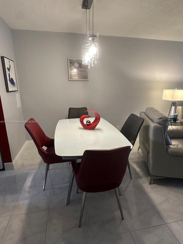 tiled dining area with a textured ceiling