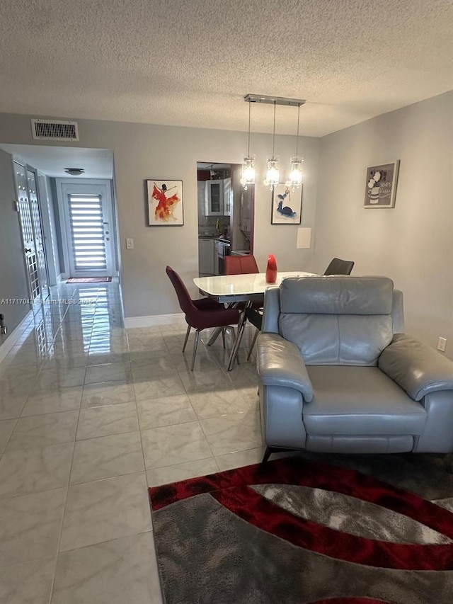 living room featuring a textured ceiling and a notable chandelier