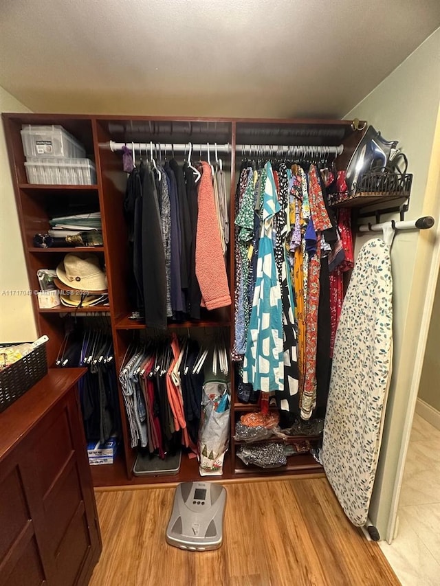 walk in closet with light hardwood / wood-style floors