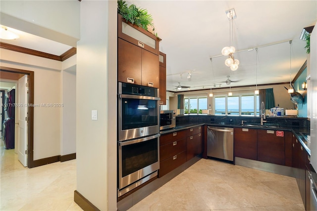 kitchen featuring ceiling fan, sink, pendant lighting, appliances with stainless steel finishes, and ornamental molding