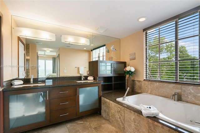 bathroom with vanity and a relaxing tiled tub