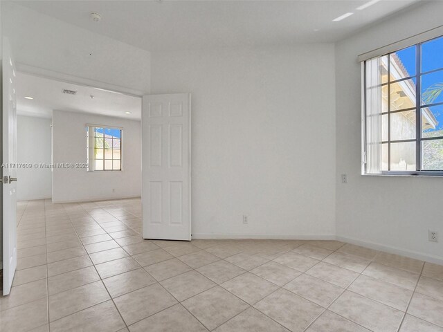 tiled spare room featuring a wealth of natural light