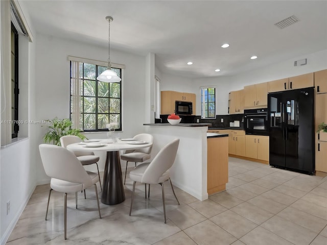 kitchen featuring tasteful backsplash, decorative light fixtures, light brown cabinets, kitchen peninsula, and black appliances