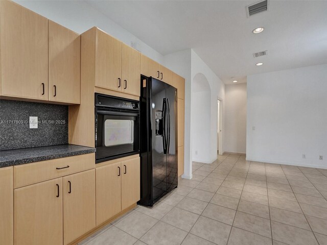 kitchen featuring light tile patterned flooring, light brown cabinetry, tasteful backsplash, and black appliances