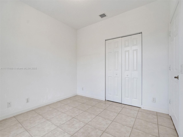 unfurnished bedroom featuring light tile patterned floors and a closet