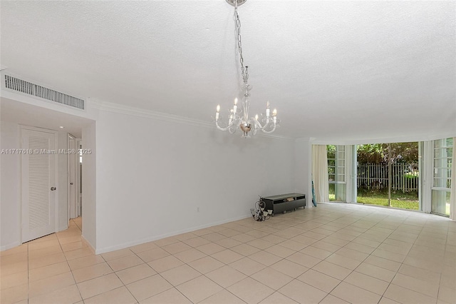 unfurnished living room featuring light tile patterned floors, ornamental molding, a textured ceiling, and an inviting chandelier