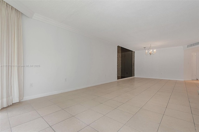 empty room featuring light tile patterned floors, ornamental molding, a textured ceiling, and an inviting chandelier