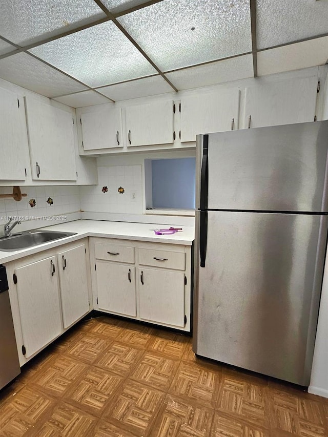 kitchen featuring backsplash, sink, white cabinets, and appliances with stainless steel finishes