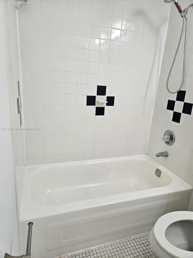 bathroom with tile patterned floors, toilet, and tiled shower / bath