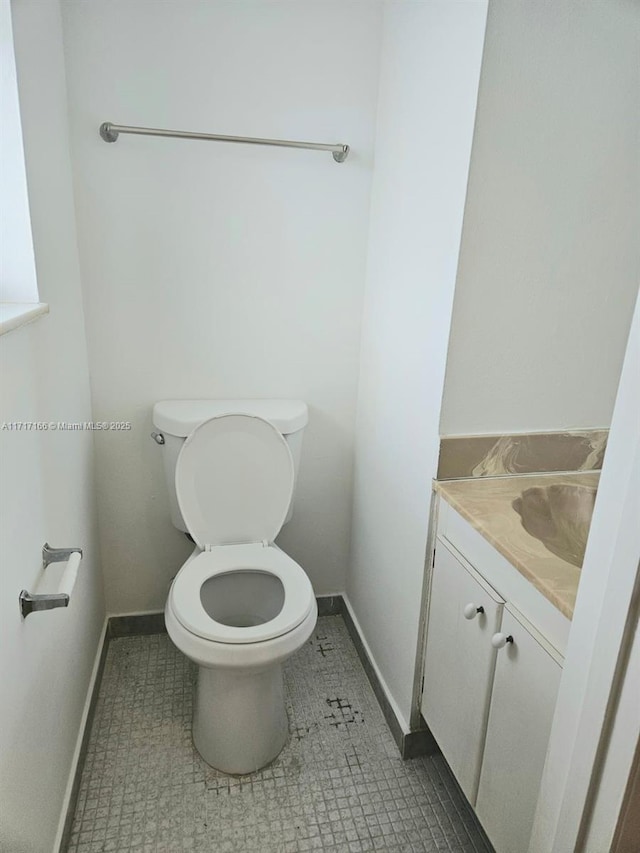 bathroom with tile patterned flooring, vanity, and toilet