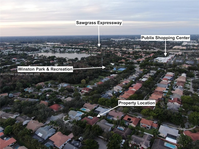 aerial view at dusk featuring a water view