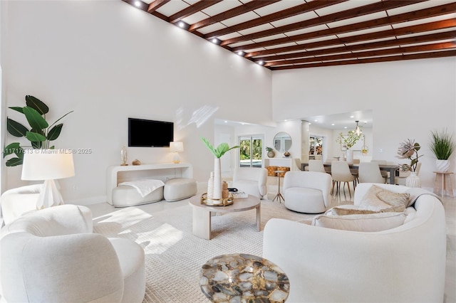 living room featuring beamed ceiling and a high ceiling