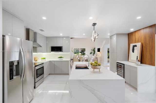 kitchen featuring pendant lighting, sink, wine cooler, appliances with stainless steel finishes, and a kitchen island