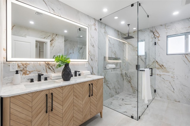 bathroom featuring vanity, a shower with door, and tile walls