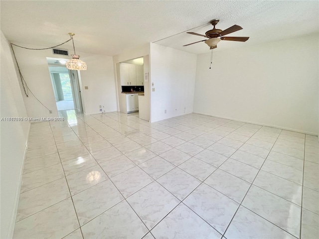 spare room with ceiling fan and a textured ceiling